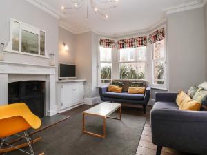 ein Wohnzimmer mit zwei Sofas und einem Kamin in der Unterkunft Kestrel in Southwold