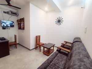 Skylight Residency Yercaud في يركواد: غرفة معيشة مع أريكة وساعة على الحائط