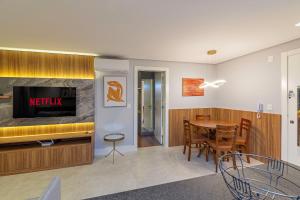 Sala de estar con mesa de comedor y TV en Ap excelente Caracol - @stayhousetemporada, en Canela 9 fotos más