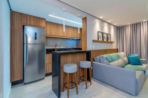 cocina con sofá y cocina con nevera en Ap excelente Caracol - @stayhousetemporada, en Canela