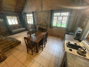a kitchen with a table and chairs in a room at Tranquila Cabaña en la Sierra - Parque La Pirámide in La Florida