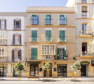 un grand bâtiment avec des fenêtres à volets verts dans l'établissement Cubo's Apartamento 33 Carreteria 3B, à Malaga