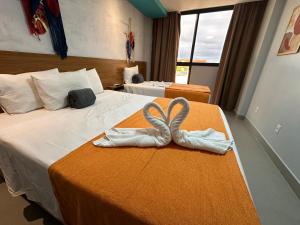 a hotel room with two beds with towels at Pousada Atlantic in Porto De Galinhas