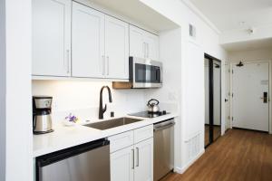 een keuken met witte kasten en een wastafel bij Premium Studio #105 in Olympic Valley