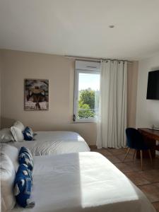 サント・マキシムにあるHotel Princesse D'Azurのベッド2台と窓が備わるホテルルームです。