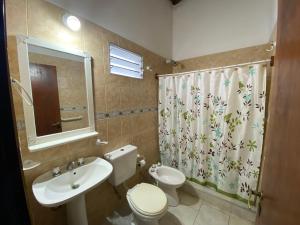 a bathroom with a sink and a toilet and a shower curtain at Departamentos Mis Girasoles in Federación