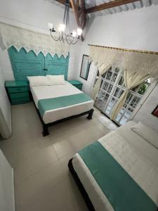 a bedroom with two beds and a chandelier at Finca Villa Antonella in Calarcá
