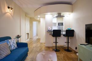 a living room with a blue couch and a kitchen at Le Refuge Parisien in Montrouge +4 photos