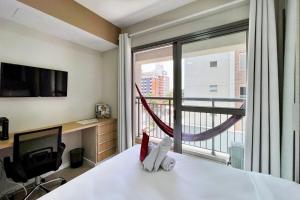 um quarto com uma cama e uma grande janela em Zainalofts7 Moema - 1km Ibira e 200m metrô 411 ID em São Paulo