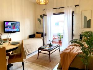 uma sala de estar com uma cama e uma mesa em Apartamento a 400 metros da praia Santa Cruz em Santa Cruz