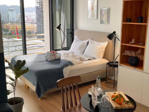 a bedroom with a bed with a view of a city at Rooftop Tirana in Tirana