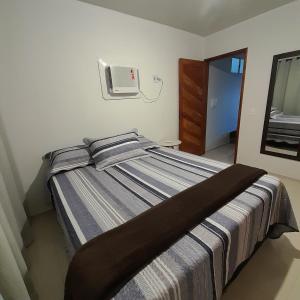 a bedroom with a bed and a tv on the wall at FLAT a 2min do relogio da flores com ar condicionado in Garanhuns