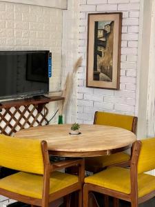 un tavolo in legno con due sedie e una televisione di Apartamento en Carrasco Sur, cerca del aeropuerto y la rambla a Montevideo