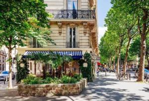 um edifício com uma varanda numa rua da cidade em Bohemian & Authentic Parisian Flat - Paris 07 em Paris