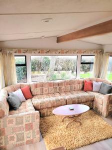 uma sala de estar com um sofá e uma mesa em Badgers Rest Loddon em Norwich