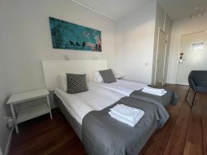 1 dormitorio con 2 camas y silla azul en Rasta Falköping, en Falkoping