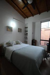 a bedroom with a large bed with a ceiling fan at Apartamento Cómodo en el Poblado in Medellín
