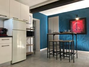uma cozinha com um frigorífico e 2 bancos de bar em Factory de villAIX em Aix-en-Provence