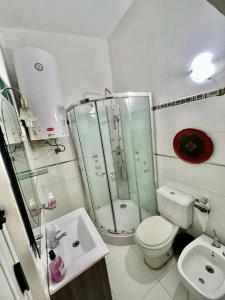 Apartamento en Carrasco Sur, cerca del aeropuerto y la rambla في مونتيفيديو: حمام مع دش ومرحاض ومغسلة