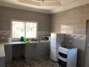eine Küche mit einem weißen Kühlschrank und einem Herd in der Unterkunft 3 bedrooms first story apartment in Sukuta