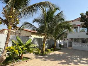 two palm trees in front of a house at 3 bedrooms first story apartment in Sukuta