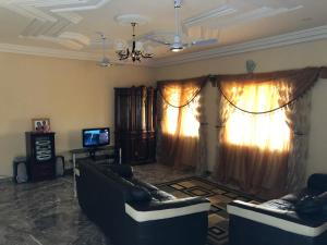 a living room with two couches and a television at 3 bedrooms first story apartment in Sukuta