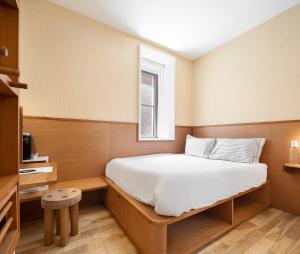 Ce lit se trouve dans une petite chambre dotée d'une fenêtre. dans l'établissement UNTITLED 3 Freeman Alley, à New York