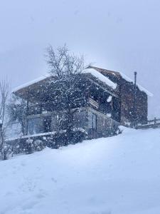a house covered in snow in front at Villa Dabderr Mestia in Mestia