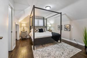 1 dormitorio con cama con dosel y alfombra en Classic Charm with Modern Flair, en Homewood