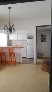 eine Küche mit weißen Schränken und einem weißen Kühlschrank in der Unterkunft Departamento Céntrico in Mar del Plata