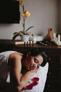 une femme qui pose sur un lit avec des roses rouges dans l'établissement Docecuartos Hotel, à San Cristóbal de Las Casas