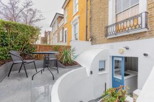 a patio with a table and chairs in front of a building at Sleek & Well-Connected Studio Flat Archway! in London