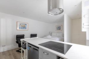 a kitchen with a white counter top and a room at Sleek & Well-Connected Studio Flat Archway! in London