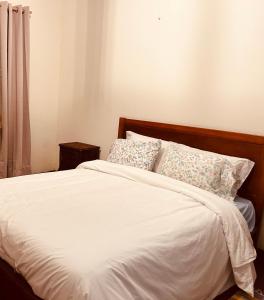 a bedroom with a bed with white sheets and pillows at Mãe Home Foz in Foz do Arelho +16 photos