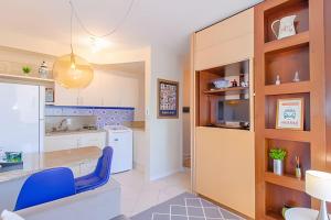 uma cozinha com uma cadeira azul num quarto em Estúdio Próximo a Beira Mar em Florianópolis