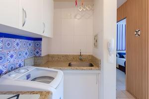 uma pequena cozinha com um lavatório e um lavatório em Estúdio Próximo a Beira Mar em Florianópolis