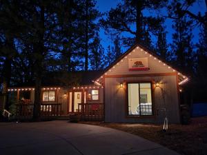 a small house with lights on it at night at Four Seasons Getaway-Private Hot Spa with Pine Tree Views-Walk to Village and Pineknot Trailhead-Plus King Bed! in Big Bear Lake