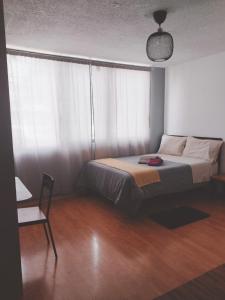 a bedroom with a bed and a chair at Modern Studio, Rooftop Charm, CDMX Center2 in Mexico City