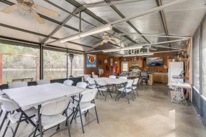 Un comedor con mesas y sillas y una cocina. en Georgia Lakefront Cabin with Fire Pit and Grills!, en Ocilla