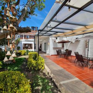 a patio with chairs and a table and an umbrella at La Huerta Hotel Boutique in Tibasosa