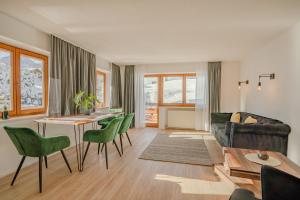 un soggiorno con tavolo e sedie verdi di Lichterberg a Hirschegg