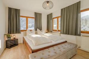 a bedroom with a large bed and windows at Lichterberg in Hirschegg