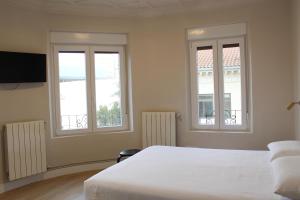 1 dormitorio con 2 ventanas y 1 cama blanca en Monasterio Centro Histórico, en Burgos