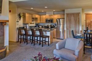 a kitchen with a bar with chairs and a kitchen with a kitchen at Grand Timber Lodge 3 bedroom - Ski-in/Ski-out in Breckenridge