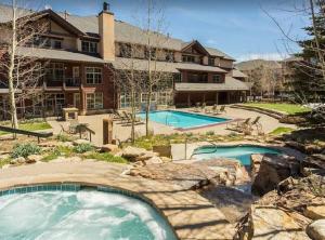 a large house with two swimming pools in a yard at Grand Timber Lodge 3 bedroom - Ski-in/Ski-out in Breckenridge