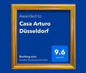 een gouden fotoframe met een bord dat wordt toegekend aan casa artura dis bij Casa Arturo Düsseldorf in Düsseldorf