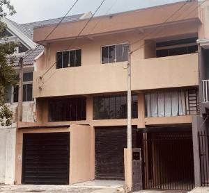 um edifício de apartamentos com duas portas de garagem e um poste em Loft Eco City 02-Espaçoso e Confortável c/ Garagem em Curitiba