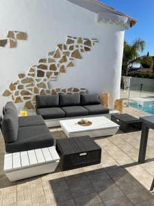 uma sala de estar com sofás e mesas e uma piscina em Magnifique Villa Piscine Pergola Proche Mer em Carqueiranne