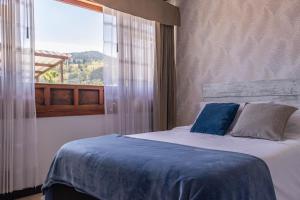 a bedroom with a bed with blue sheets and a window at Casa La Huerta in Tibasosa