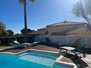 uma piscina com espreguiçadeiras e uma piscina em Magnifique Villa Piscine Pergola Proche Mer em Carqueiranne